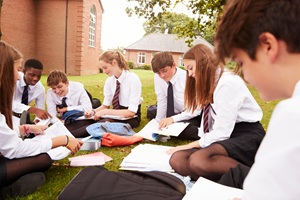 Secondary school students sat outside together on break