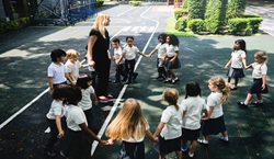 Children in playground with teacher